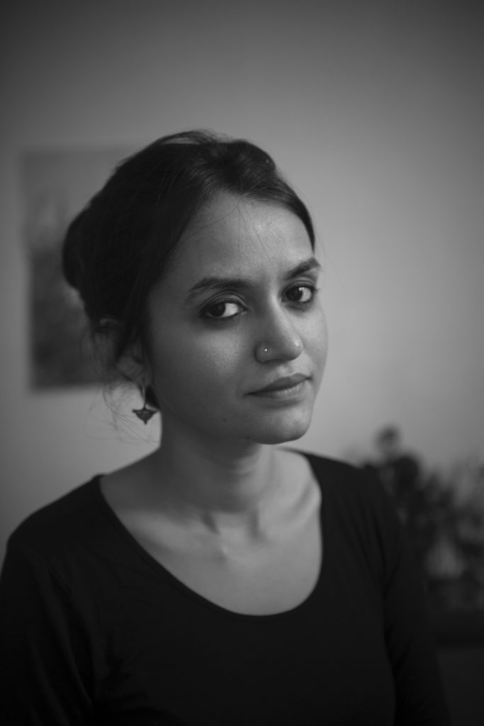 The image is a black-and-white portrait of filmmaker Payal Kapadia, the director of A Night of Knowing Nothing. She is an Indian woman with dark hair which is up in a bun.